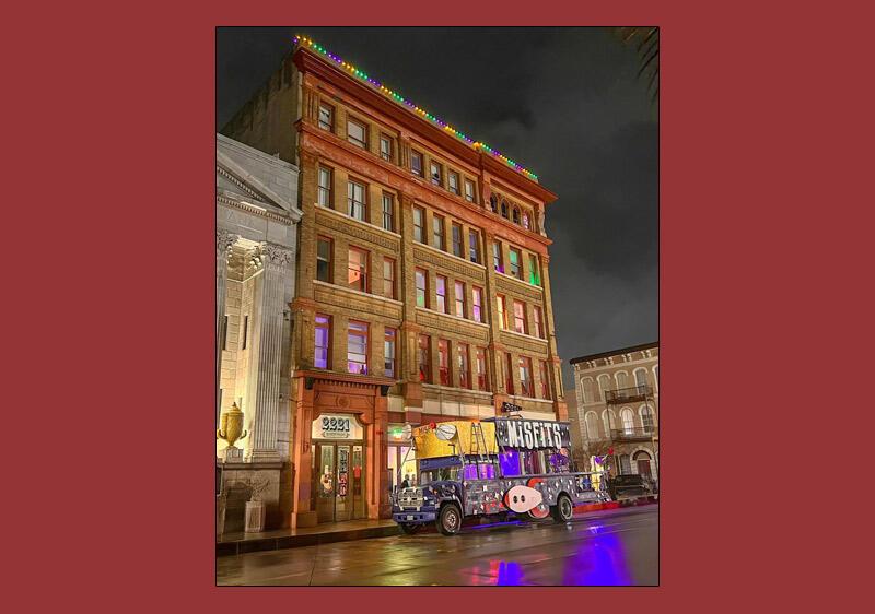 photo of a historic building at night with the Misfits bus in front